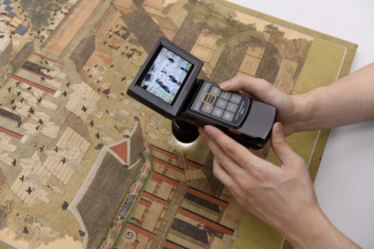 리움미술관 보존연구실에서 평안감사향연도(平安監司饗宴圖) 상태조사를 하고 있다. 삼성문화재단 제공